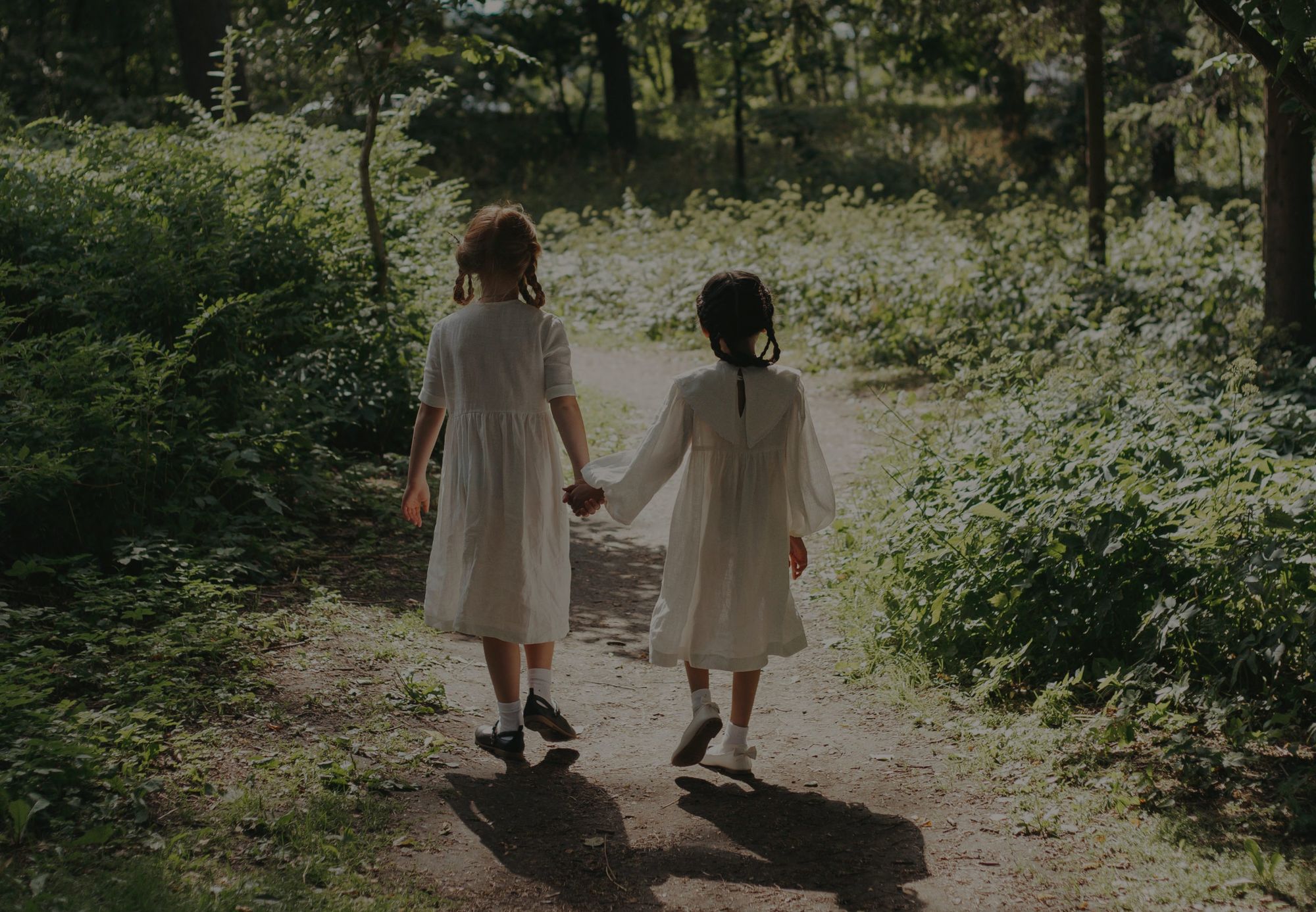 Dos niñas de la mano por un camino del bosque: Huérfanos de Guerra